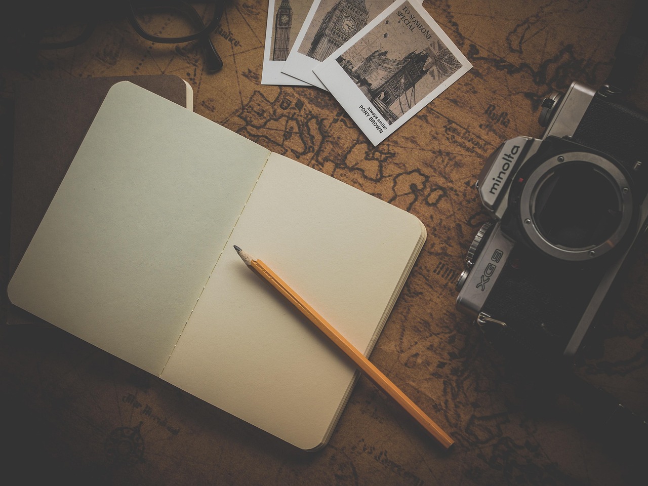 Open travel notebook crowded with a packed schedule and timetables, sitting next to a paper map