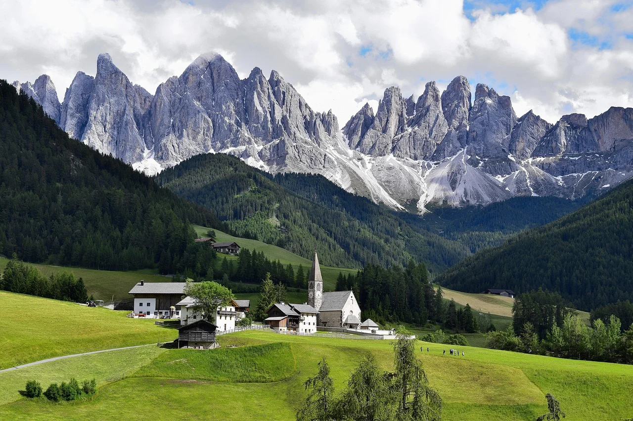 Sommets dentelés des Dolomites au-dessus d'une vallée verdoyante