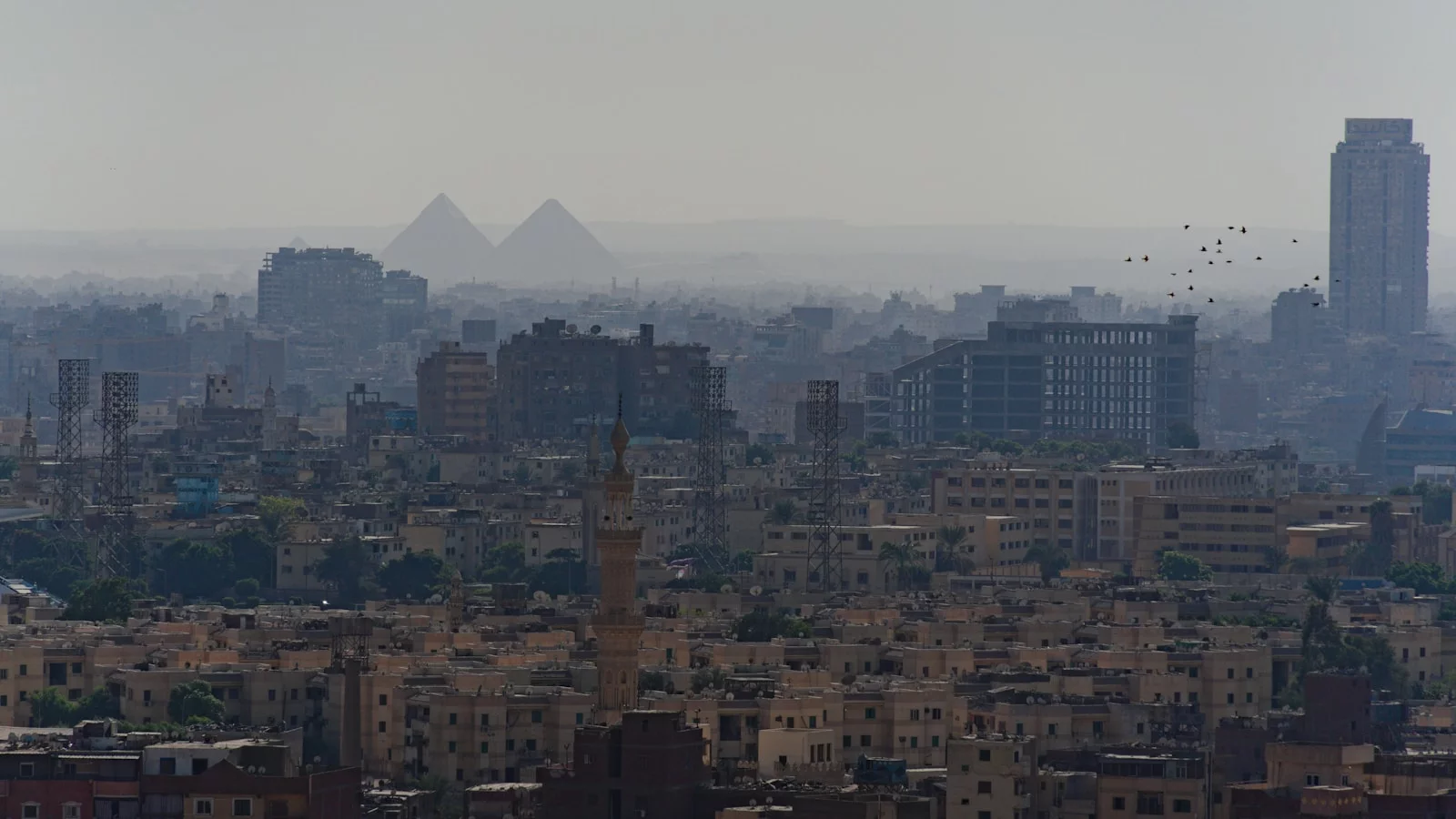 Les pyramides de Gizeh dans la brume au-dessus de l'étendue urbaine du Caire.