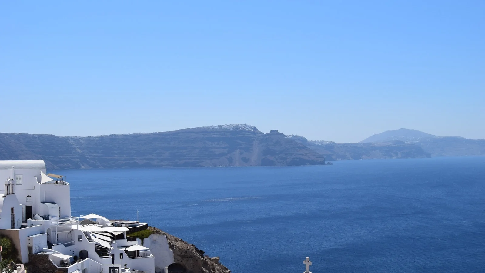 Maisons blanches à dômes bleus d'Oia à Santorin surplombant la mer Égée