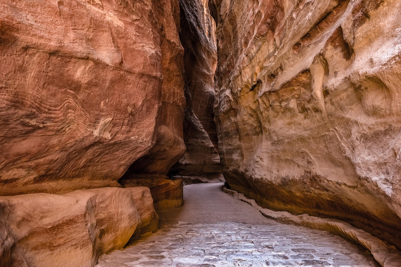 Le Siq de Petra, canyon étroit aux hautes parois rouges, avec un chemin dallé au sol