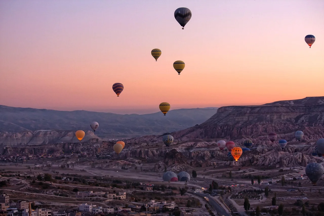 Montgolfières multicolores au lever du soleil au-dessus des cheminées de fée de Cappadoce.