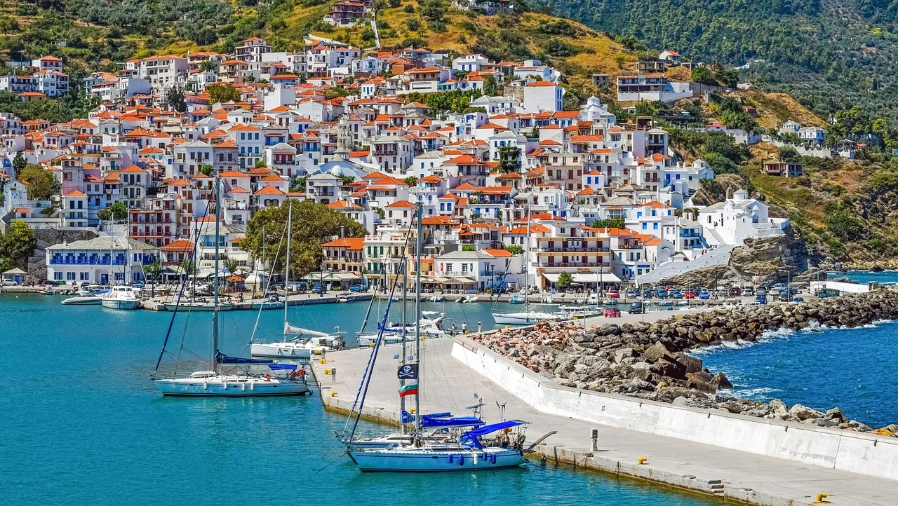 Port d'une île grecque avec voiliers et maisons blanches en arrière-saison