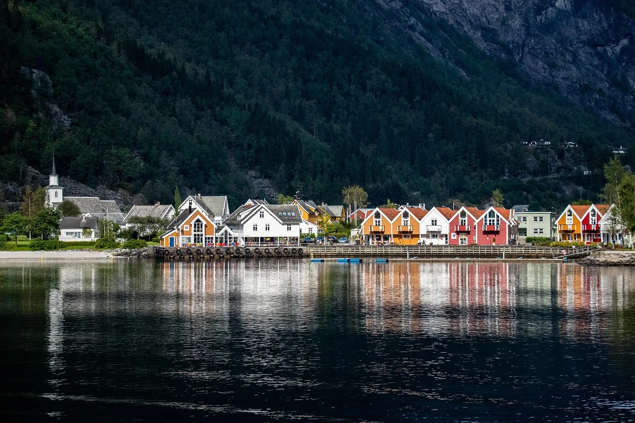 Village de fjord norvégien aux maisons de bois colorées, montagnes et reflets dans l'eau