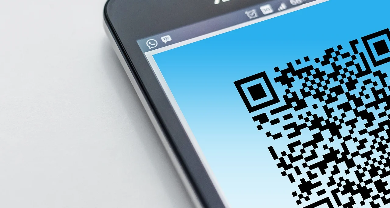 Écran de smartphone affichant un grand QR code sur fond bleu, vu en gros plan