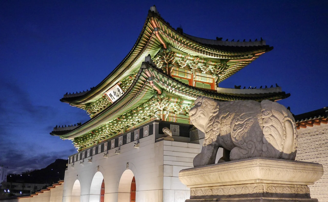 La porte Gwanghwamun du palais Gyeongbokgung illuminée la nuit, gardée par une statue de haetae, à Séoul