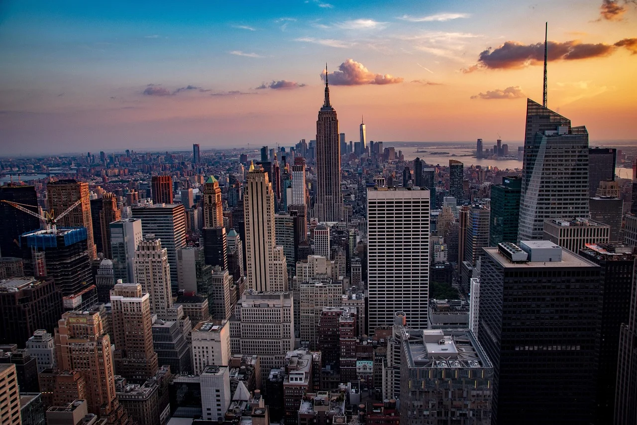 Vue aérienne de Manhattan au coucher du soleil, avec l'Empire State Building au centre de la skyline de New York.