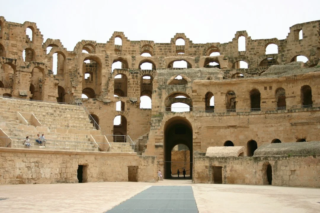 Arène et gradins de l'amphithéâtre romain d'El Jem en Tunisie, avec ses arcades de pierre ocre