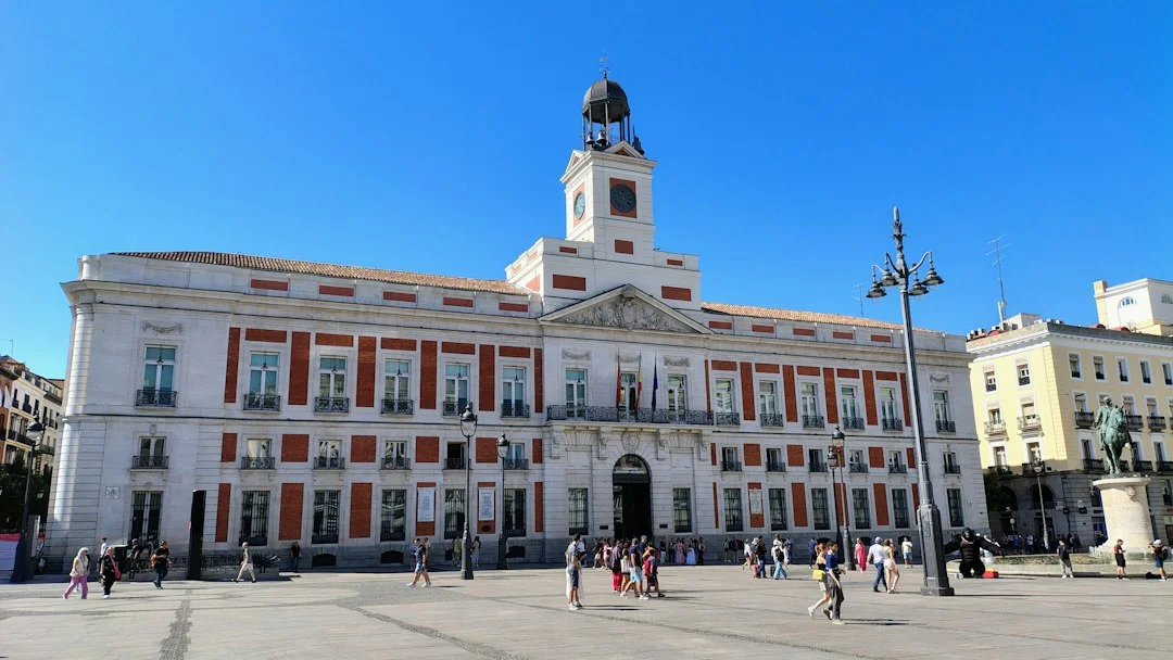 Façade blanche et rouge de la Real Casa de Correos et son horloge, sur la Puerta del Sol à Madrid