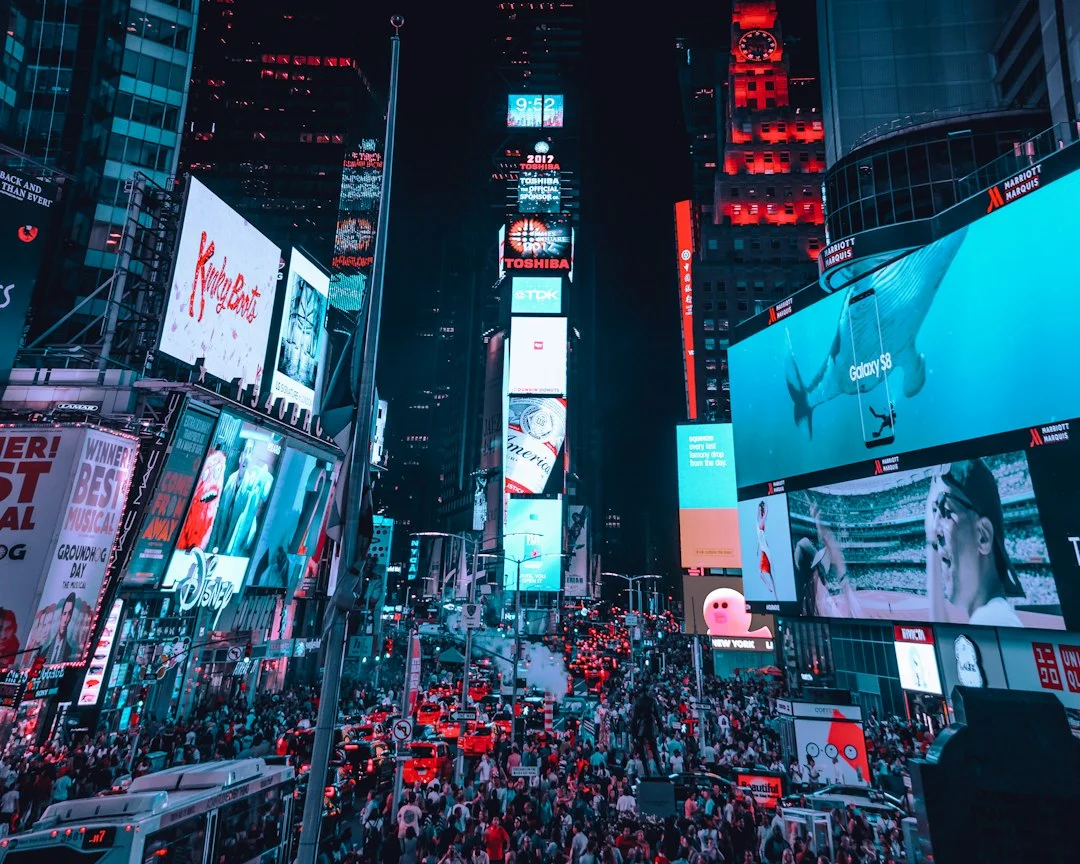 Foule et écrans publicitaires géants de Times Square à New York, la nuit