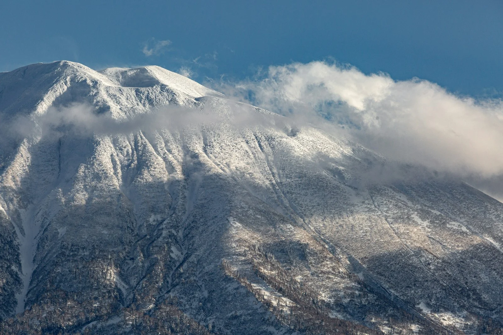 Le mont Yōtei enneigé sous un ciel bleu, vu depuis Niseko sur l'île de Hokkaido au Japon