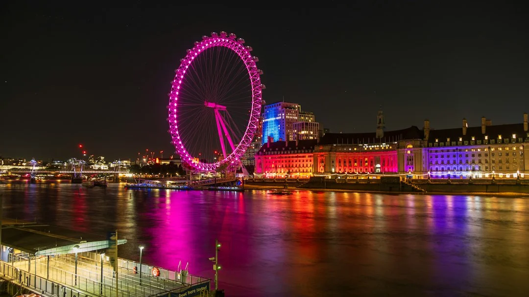 London Eye illuminé en rose la nuit, au bord de la Tamise à Londres