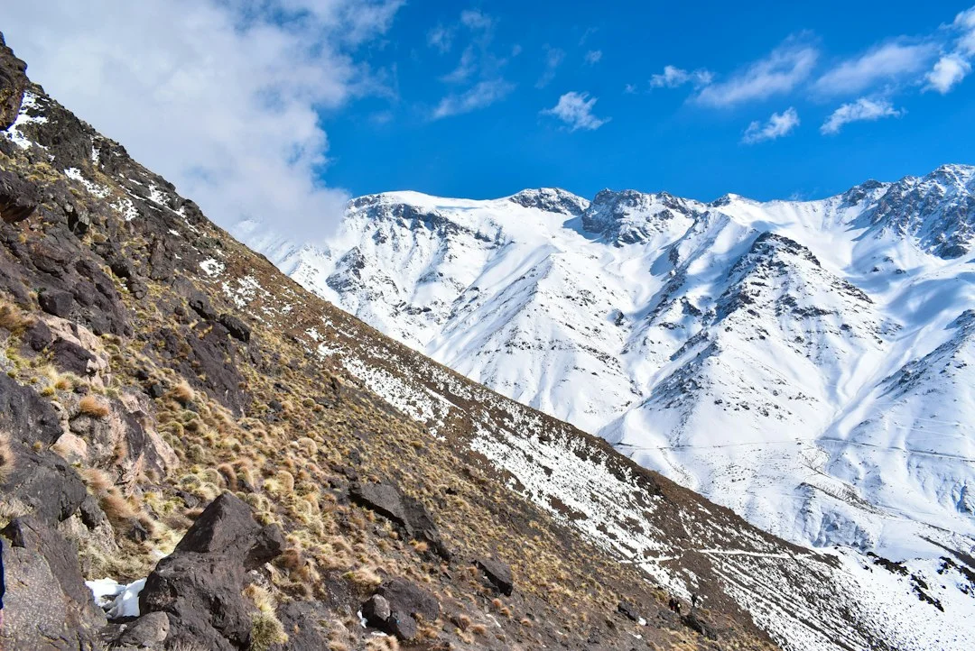 Sommets enneigés du Haut Atlas marocain près de Tacheddirt, au-dessus d'un versant de rocaille et d'herbes sèches
