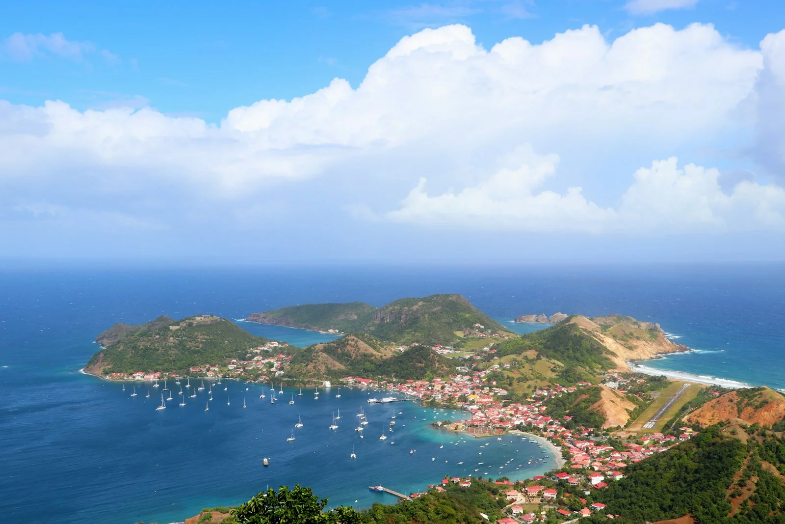 Vue aérienne de la baie de Terre-de-Haut aux Saintes en Guadeloupe, voiliers au mouillage et collines vertes